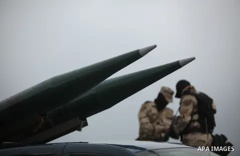 Palestinian members of al-Qassam Brigades, the armed wing of the Hamas movement, display a home-made Qassam rocket during a military parade marking the 27th anniversary of Hamas' founding, in Gaza City December 14, 2014....