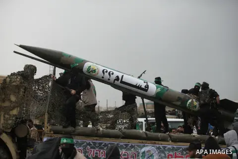 Palestinian members of al-Qassam Brigades, the armed wing of the Hamas movement, display a home-made Qassam rocket during a military parade marking the 27th anniversary of Hamas' founding, in Gaza City December 14, 2014....