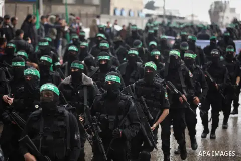 Palestinian members of al-Qassam Brigades, the armed wing of the Hamas movement, hold weapons as they take part in a military parade marking the 27th anniversary of Hamas' founding, in Gaza City December 14, 2014. Photo...