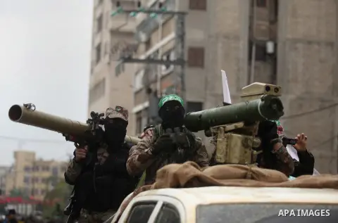 Palestinian members of the marine unit of al-Qassam Brigades, the armed wing of the Hamas movement, ride in a pickup truck as they take part in a military parade marking the 27th anniversary of Hamas' founding, in Gaza C...