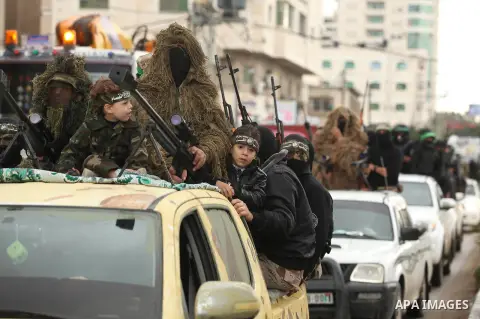 Palestinian members of the marine unit of al-Qassam Brigades, the armed wing of the Hamas movement, ride in a pickup truck as they take part in a military parade marking the 27th anniversary of Hamas' founding, in Gaza C...