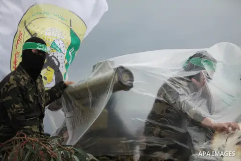 Palestinian members of al-Qassam Brigades, the armed wing of the Hamas movement, display a home-made Qassam rocket during a military parade marking the 27th anniversary of Hamas' founding, in Gaza City December 14, 2014....