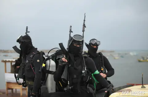 Palestinian members of the marine unit of al-Qassam Brigades, the armed wing of the Hamas movement, ride in a pickup truck as they take part in a military parade marking the 27th anniversary of Hamas' founding, in Gaza C...