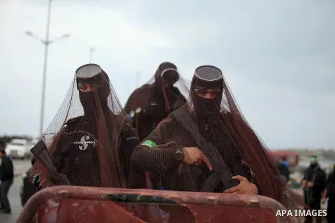Palestinian members of the marine unit of al-Qassam Brigades, the armed wing of the Hamas movement, ride in a pickup truck as they take part in a military parade marking the 27th anniversary of Hamas' founding, in Gaza C...