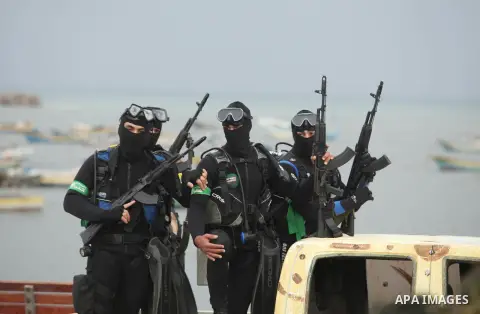 Palestinian members of the marine unit of al-Qassam Brigades, the armed wing of the Hamas movement, ride in a pickup truck as they take part in a military parade marking the 27th anniversary of Hamas' founding, in Gaza C...
