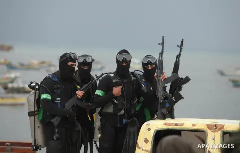 Palestinian members of the marine unit of al-Qassam Brigades, the armed wing of the Hamas movement, ride in a pickup truck as they take part in a military parade marking the 27th anniversary of Hamas' founding, in Gaza C...