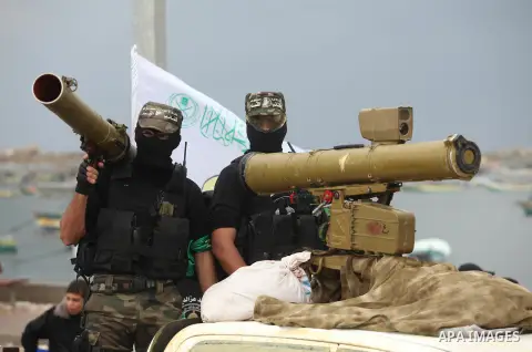 Palestinian members of al-Qassam Brigades, the armed wing of the Hamas movement, display a home-made Qassam rocket during a military parade marking the 27th anniversary of Hamas' founding, in Gaza City December 14, 2014....