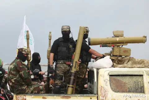Palestinian members of al-Qassam Brigades, the armed wing of the Hamas movement, display a home-made Qassam rocket during a military parade marking the 27th anniversary of Hamas' founding, in Gaza City December 14, 2014....