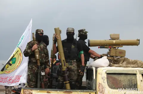 Palestinian members of al-Qassam Brigades, the armed wing of the Hamas movement, display a home-made Qassam rocket during a military parade marking the 27th anniversary of Hamas' founding, in Gaza City December 14, 2014....