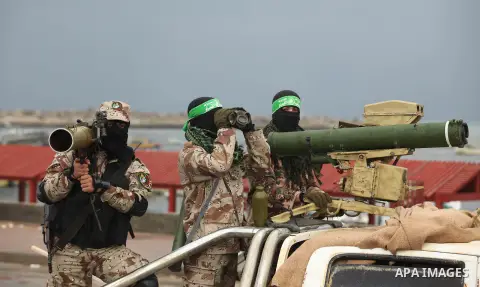 Palestinian members of al-Qassam Brigades, the armed wing of the Hamas movement, display a home-made Qassam rocket during a military parade marking the 27th anniversary of Hamas' founding, in Gaza City December 14, 2014....