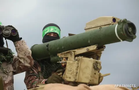 Palestinian members of al-Qassam Brigades, the armed wing of the Hamas movement, display a home-made Qassam rocket during a military parade marking the 27th anniversary of Hamas' founding, in Gaza City December 14, 2014....