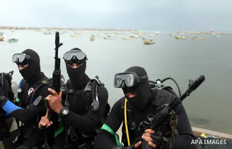Palestinian members of the marine unit of al-Qassam Brigades, the armed wing of the Hamas movement, take part in a military parade marking the 27th anniversary of Hamas' founding, in Gaza City December 14, 2014. Photo by...