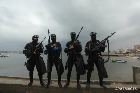 Palestinian members of the marine unit of al-Qassam Brigades, the armed wing of the Hamas movement, take part in a military parade marking the 27th anniversary of Hamas' founding, in Gaza City December 14, 2014. Photo by...