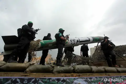 Palestinian members of al-Qassam Brigades, the armed wing of the Hamas movement, display a home-made Qassam rocket during a military parade marking the 27th anniversary of Hamas' founding, in Gaza City December 14, 2014....