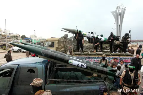Palestinian members of al-Qassam Brigades, the armed wing of the Hamas movement, display a home-made Qassam rocket during a military parade marking the 27th anniversary of Hamas' founding, in Gaza City December 14, 2014....
