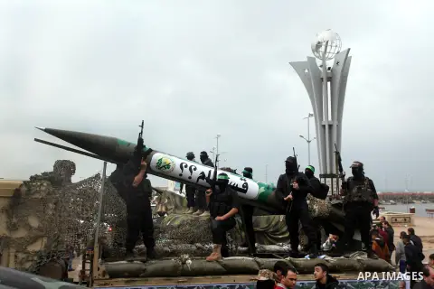Palestinian members of al-Qassam Brigades, the armed wing of the Hamas movement, display a home-made Qassam rocket during a military parade marking the 27th anniversary of Hamas' founding, in Gaza City December 14, 2014....