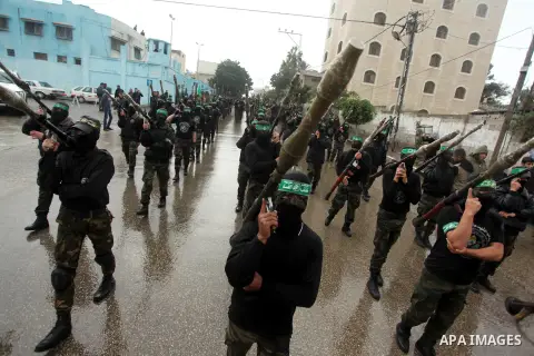 Palestinian members of al-Qassam Brigades, the armed wing of the Hamas movement, hold weapons as they take part in a military parade marking the 27th anniversary of Hamas' founding, in Gaza City December 14, 2014. Photo...