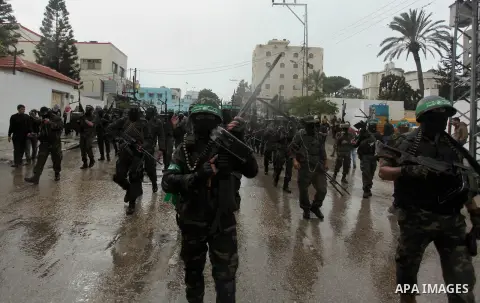 Palestinian members of al-Qassam Brigades, the armed wing of the Hamas movement, hold weapons as they take part in a military parade marking the 27th anniversary of Hamas' founding, in Gaza City December 14, 2014. Photo...