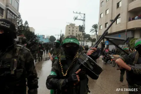 Palestinian members of al-Qassam Brigades, the armed wing of the Hamas movement, hold weapons as they take part in a military parade marking the 27th anniversary of Hamas' founding, in Gaza City December 14, 2014. Photo...
