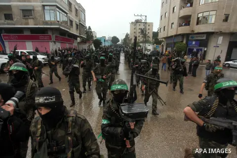 Palestinian members of al-Qassam Brigades, the armed wing of the Hamas movement, hold weapons as they take part in a military parade marking the 27th anniversary of Hamas' founding, in Gaza City December 14, 2014. Photo...