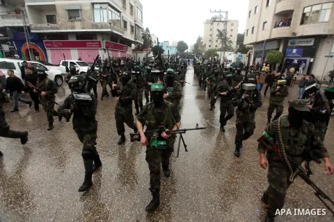 Palestinian members of al-Qassam Brigades, the armed wing of the Hamas movement, hold weapons as they take part in a military parade marking the 27th anniversary of Hamas' founding, in Gaza City December 14, 2014. Photo...