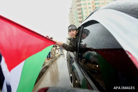 Palestinian members of al-Qassam Brigades, the armed wing of the Hamas movement, hold weapons as they take part in a military parade marking the 27th anniversary of Hamas' founding, in Gaza City December 14, 2014. Photo...