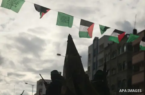 Palestinian members of al-Qassam Brigades, the armed wing of the Hamas movement, hold weapons as they take part in a military parade marking the 27th anniversary of Hamas' founding, in Gaza City December 14, 2014. Photo...