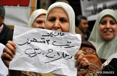 Egyptian workers and employees of Industrial and Engineering Enterprises Co, take part in a protest demanding for their salaries, outside Egyptian cabinet, in Cairo on December 14, 2014 . Photo by Amr sayed