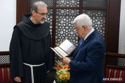 Palestinian President Mahmoud Abbas receives the invitation of the Mass glorious of Christmas, at his headquarter in the West Bank city of Ramallah, December 14, 2014. Photo by Thaer Ganaim