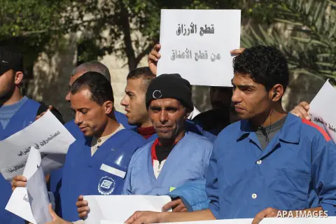Palestinian cleaners hold banners during a protest to demand their salaries, in Gaza City December 16, 2014. Photo by Mohammed Asad