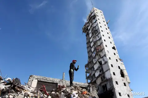 A Palestinian worker removes the rubbles from the Italian Complex, which was destroyed by Israeli air strike during the Israel-Gaza conflict, in Gaza city on December 17, 2014. Photo by Ashraf Amra