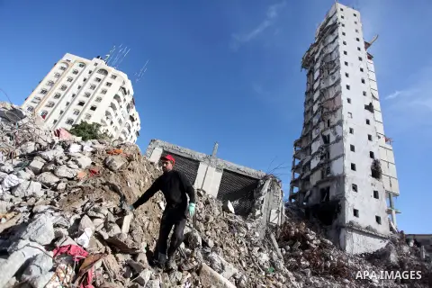 A Palestinian worker removes the rubbles from the Italian Complex, which was destroyed by Israeli air strike during the Israel-Gaza conflict, in Gaza city on December 17, 2014. Photo by Ashraf Amra