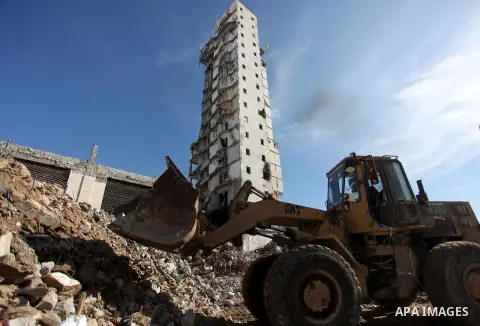 A Palestinian worker removes the rubbles from the Italian Complex, which was destroyed by Israeli air strike during the Israel-Gaza conflict, in Gaza city on December 17, 2014. Photo by Ashraf Amra