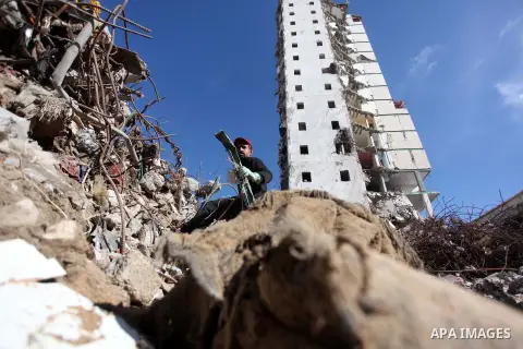 A Palestinian worker removes the rubbles from the Italian Complex, which was destroyed by Israeli air strike during the Israel-Gaza conflict, in Gaza city on December 17, 2014. Photo by Ashraf Amra