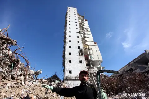 A Palestinian worker removes the rubbles from the Italian Complex, which was destroyed by Israeli air strike during the Israel-Gaza conflict, in Gaza city on December 17, 2014. Photo by Ashraf Amra