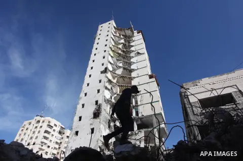 A Palestinian worker removes the rubbles from the Italian Complex, which was destroyed by Israeli air strike during the Israel-Gaza conflict, in Gaza city on December 17, 2014. Photo by Ashraf Amra