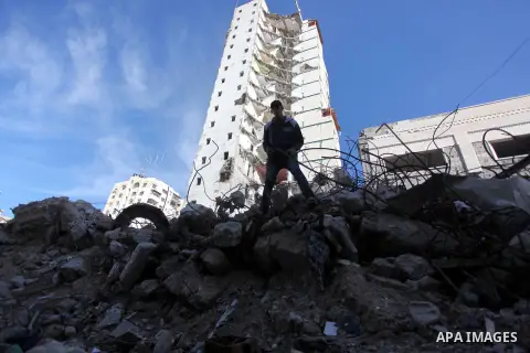A Palestinian worker removes the rubbles from the Italian Complex, which was destroyed by Israeli air strike during the Israel-Gaza conflict, in Gaza city on December 17, 2014. Photo by Ashraf Amra