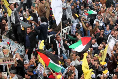 Palestinian supporters of former leader of Fatah in Gaza, Mohammed Dahlan, hold posters depicting Dahlan during a protest against Palestinian President Mahmoud Abbas in Gaza City December 18, 2014. Dahlan, who lives in e...