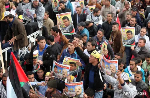 Palestinian supporters of former leader of Fatah in Gaza, Mohammed Dahlan, hold posters depicting Dahlan during a protest against Palestinian President Mahmoud Abbas in Gaza City December 18, 2014. Dahlan, who lives in e...