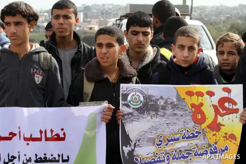Palestinians gather during a protest against the delay in acquiring building material in front of Eriz crossing border, in the norhtern Gaza Strip on December 18, 2014. According to housing minister Mufeed al-Hasayna, Ga...