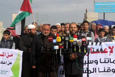 Palestinians gather during a protest against the delay in acquiring building material in front of Eriz crossing border, in the norhtern Gaza Strip on December 18, 2014. According to housing minister Mufeed al-Hasayna, Ga...