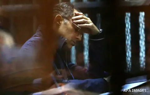 Gamal Mubarak, the son of former president Hosni Mubarak sits in a courtroom cage in Cairo, December 18, 2014. The two sons of Egypt's former president were back in court facing charges of stock market manipulation. Phot...