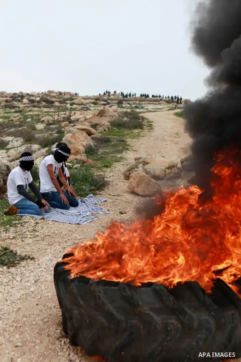 Masked Palestinian youths pray before clashes with Israeli border police against Israeli settlements in the West Bank village of Turmus Aya, near Ramallah December 19, 2014. Photo by Shadi Hatem