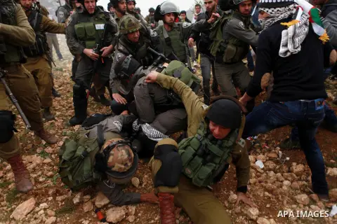 Israeli border police detain a Palestinian protester during clashes following a protest against Israeli settlements in the West Bank village of Turmus Aya, near Ramallah December 19, 2014. Photo by Shadi Hatem