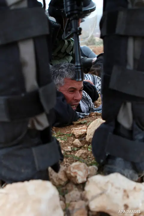 Israeli border police detain a Palestinian protester during clashes following a protest against Israeli settlements in the West Bank village of Turmus Aya, near Ramallah December 19, 2014. Photo by Shadi Hatem