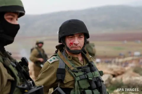 A wounded Israeli border police man take position during clashes following a demonstration against Israeli settlements in the West Bank village of Turmus Aya, near Ramallah December 19, 2014. Photo by Shadi Hatem