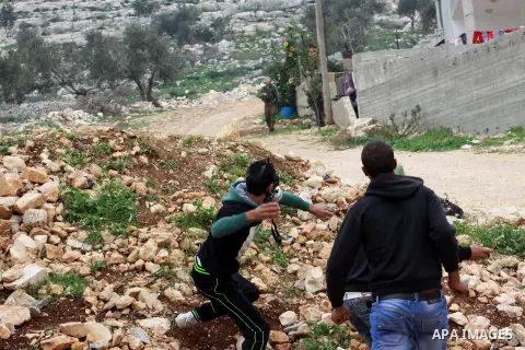 Palestinian youths throw stones at Israeli security forces during clashes in a protest against the expropriation of Palestinian land by Israel following Friday prayers in the village of Kafr Qaddum, near Nablus, Dec. 19,...