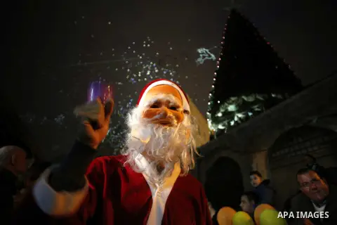 People wearing Santa Claus outfits attend a Christmas tree lighting ceremony at Jerusalem's Old City December 19, 2014. Photo by Muammar Awad