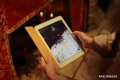 Christian worshiper takes a picture for the Grotto at the Church of the Nativity, believed to be the birthplace of Jesus Christ, in the West Bank biblical town of Bethlehem on December 24, 2014. This year, Israel granted...