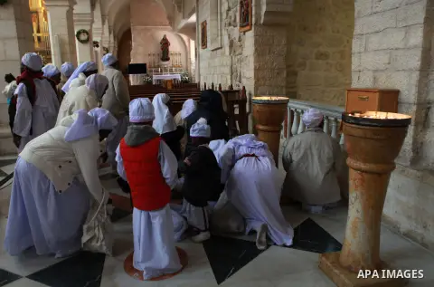 Nigerian pilgrims arrive to pray as part of Christmas celebrations inside the Grotto at the Church of the Nativity, believed to be the birthplace of Jesus Christ, on December 24, 2014 in the West Bank biblical town of Be...